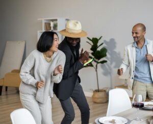 Positive diverse friends dancing while celebrating Thanksgiving