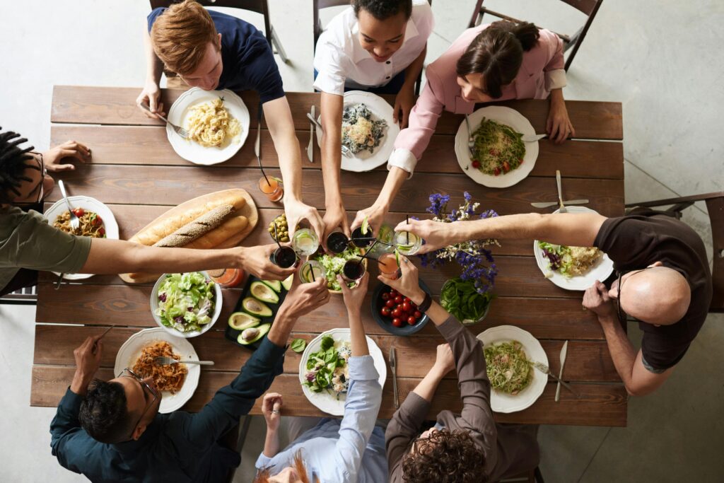 A vibrant group cheers over a delicious meal, showcasing friendship and togetherness.